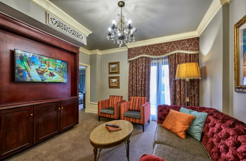 Executive Suite lounge with chandelier and tufted sofa at the D'oreale Grande, Emperors Palace