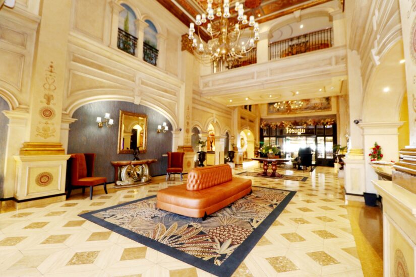 Grand foyer with chandelier and leather bench at the D'oreale Grande, Emperors Palace