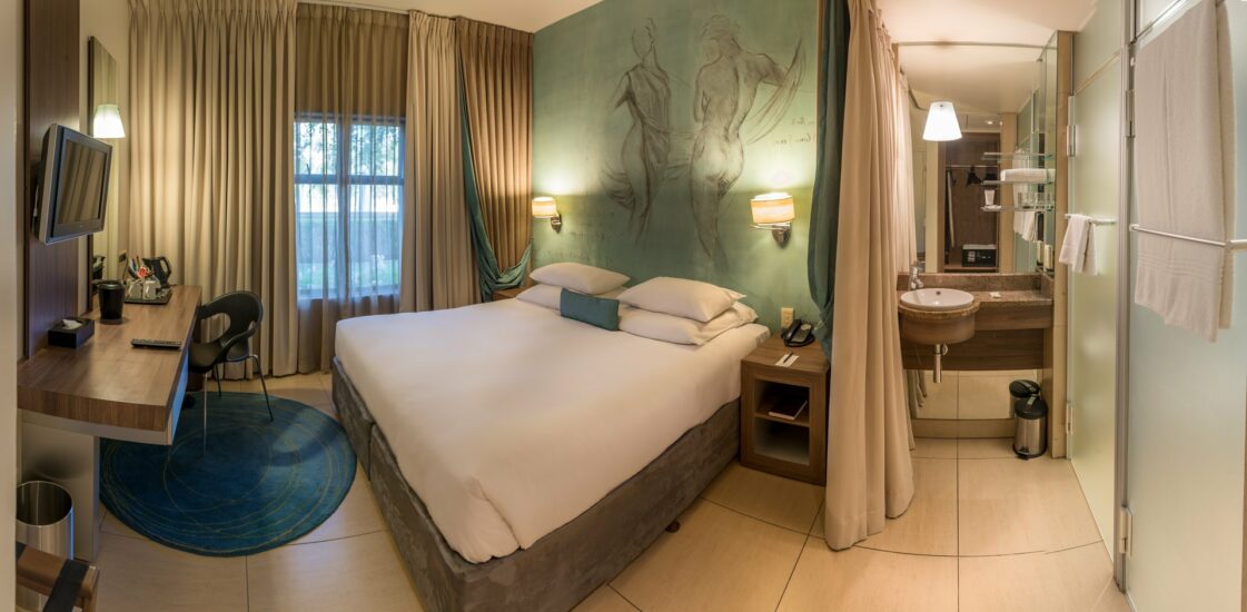 Classic King Room with a mural headboard, work desk and open ensuite at Metcourt, Emperors Palace