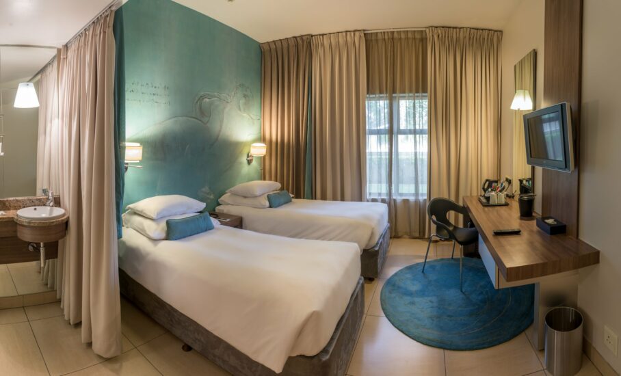 Classic Twin Room with separated beds beneath a horse mural at Metcourt, Emperors Palace