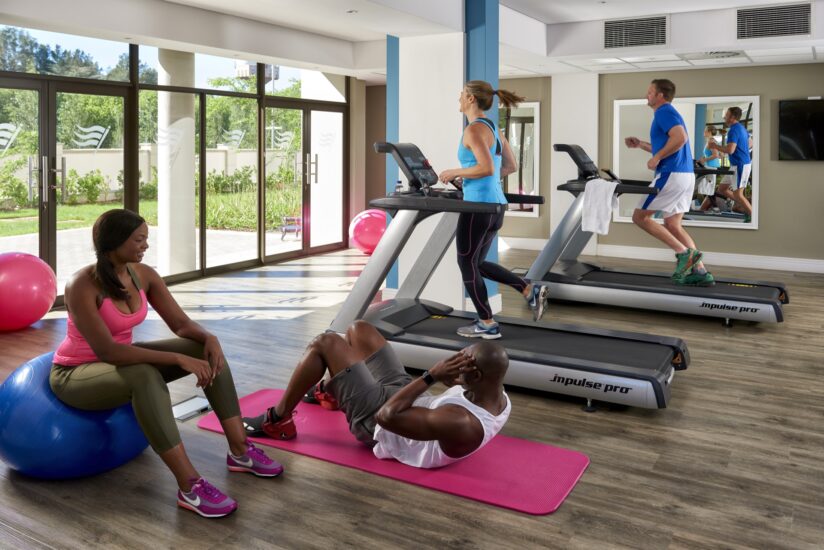 Guests exercising on treadmills and mats in the bright Metcourt gym at Emperors Palace